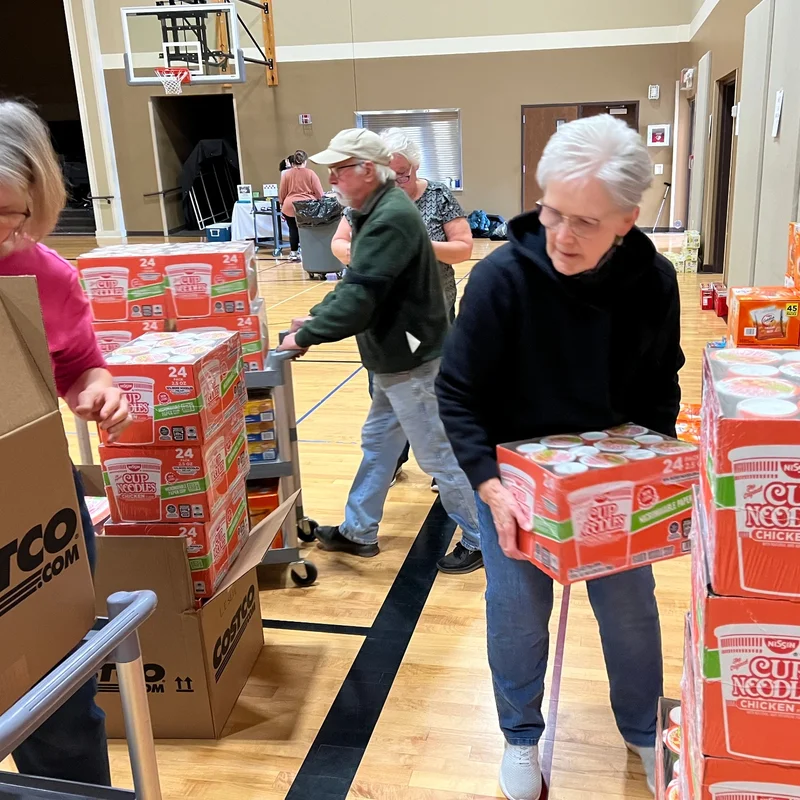 Volunteers sorting donation boxes in a gymnasium