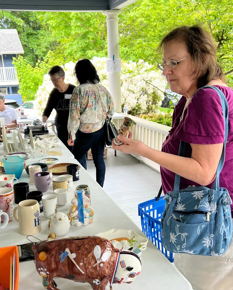 A shopper examines a figurine at the Porch Sale