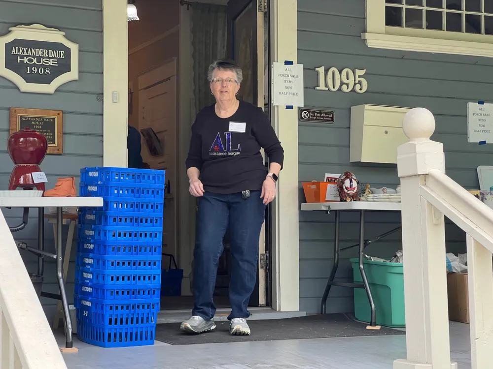 A volunteer steps out the front door of the Alexander Daue House during the Porch Sale